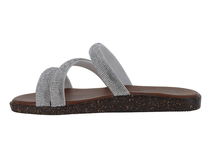 Sandalia plana color plata con tiras brillantes y suela marrón.