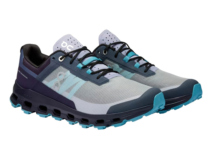 Tenis deportivos ON Cloud Vista en colores azul marino y gris con suela robusta en azul claro.
