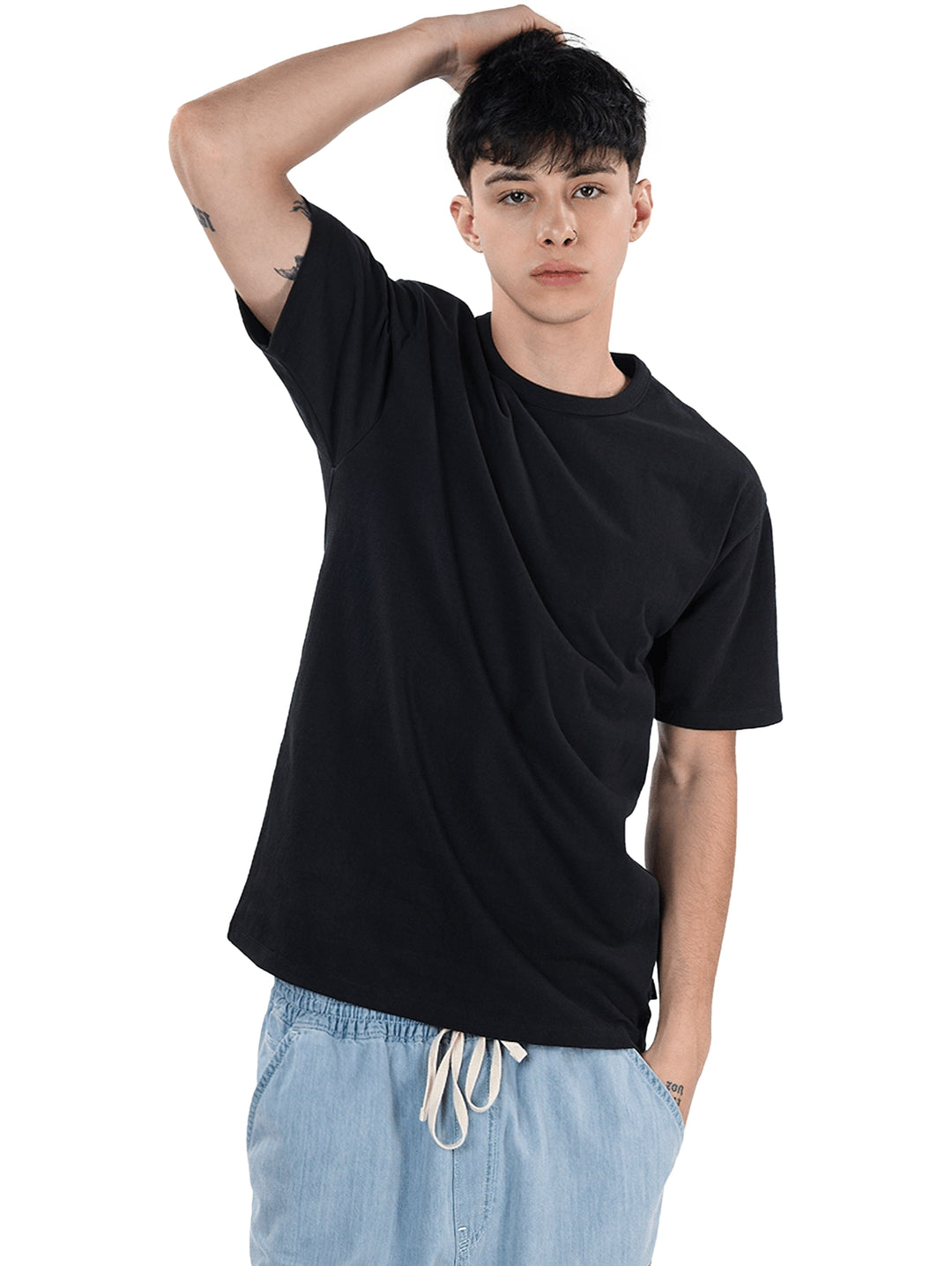 Hombre vistiendo una camiseta negra de manga corta y cuello redondo.