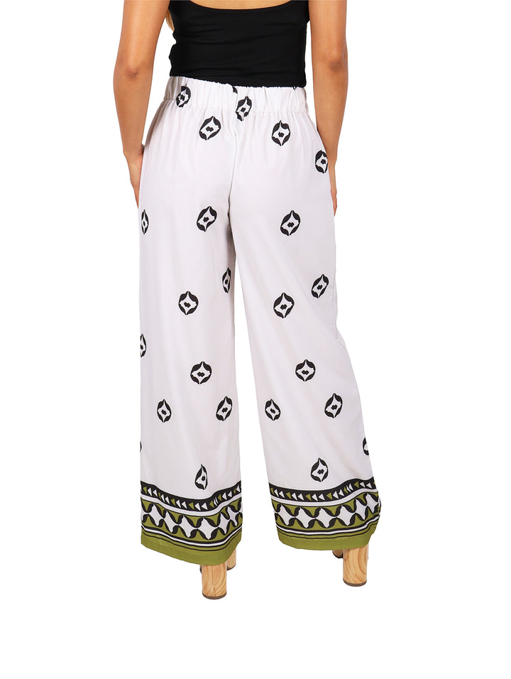 Pantalones culotte de maternidad color blanco con estampado geométrico negro y detalle verde en el ruedo.