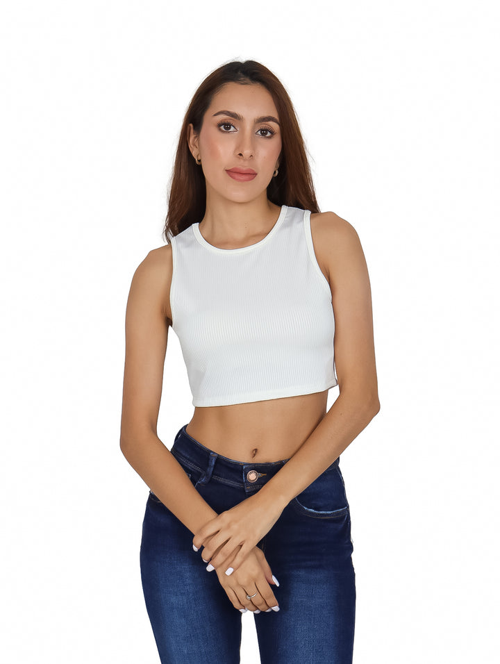 Mujer vistiendo un top corto blanco sin mangas de textura acanalada y cuello redondo.