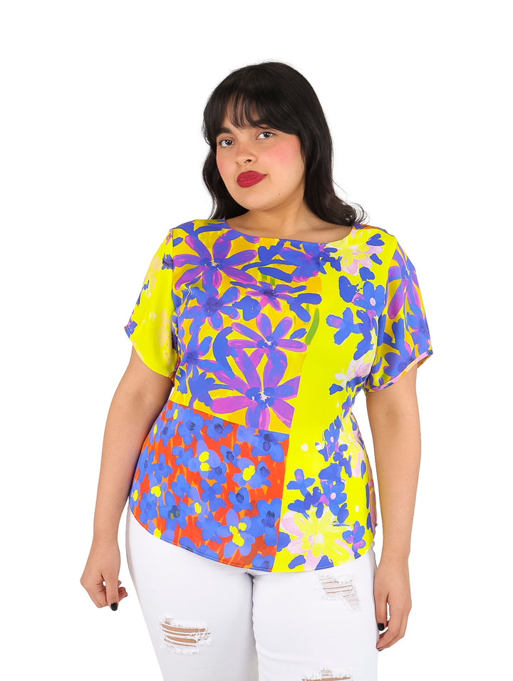 Blusa de manga corta con estampado multicolor en tonos amarillo, morado y naranja.
