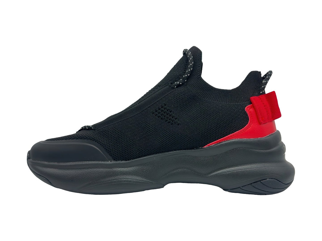 Tenis deportivos Champion color negro con detalle rojo en el talón y suela gruesa.