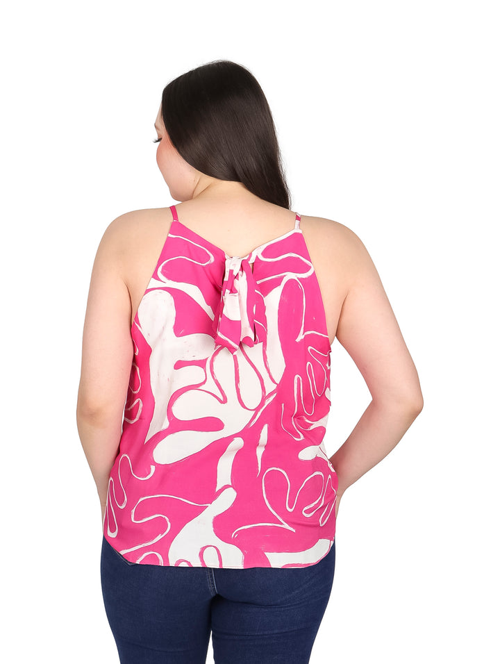 Mujer vistiendo blusa sin mangas color fucsia con estampado abstracto blanco.