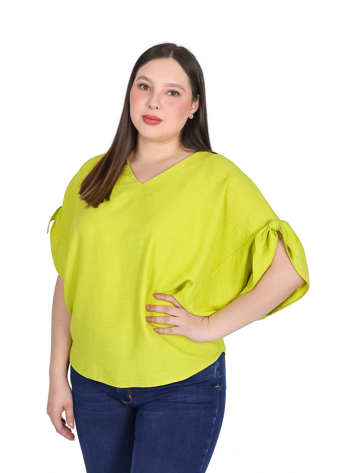 Mujer vistiendo una blusa color lima de corte curvy con cuello en V y detalles en las mangas.