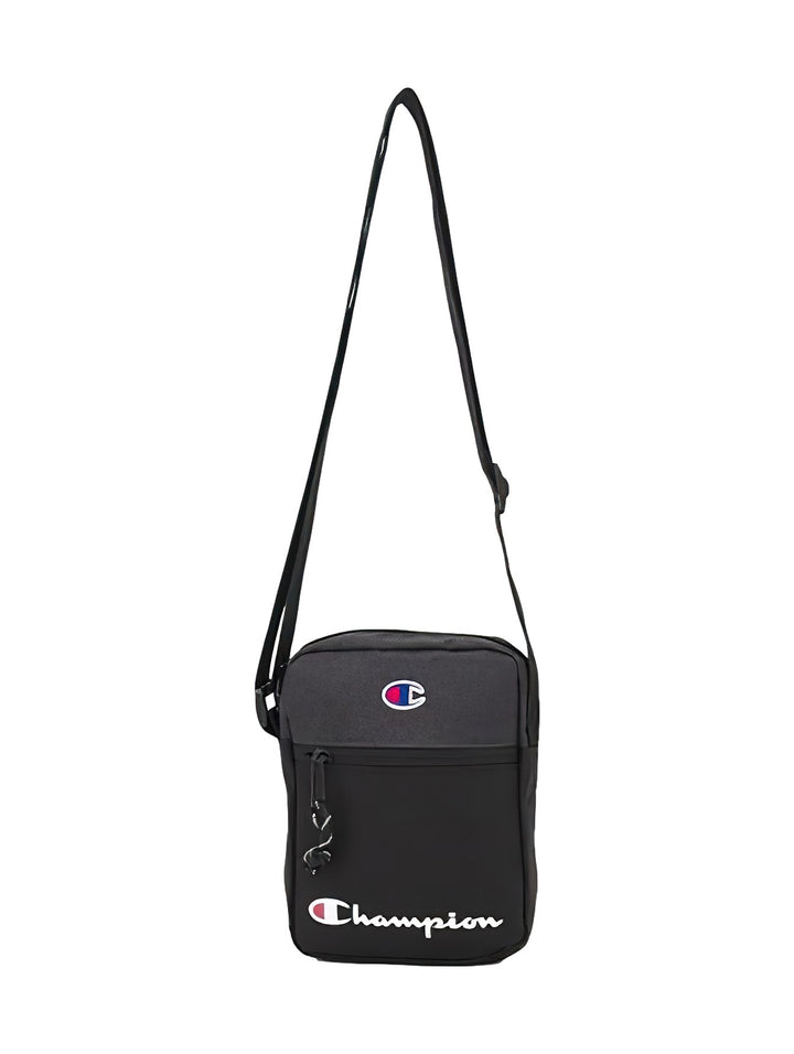 Bolso crossbody Champion de color negro con logotipo frontal y correa ajustable.