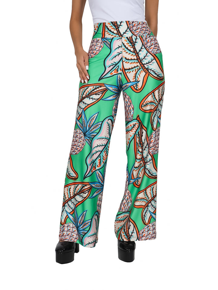 Pantalón verde de pierna ancha con estampado tropical de piñas y hojas en tonos naranja y azul.
