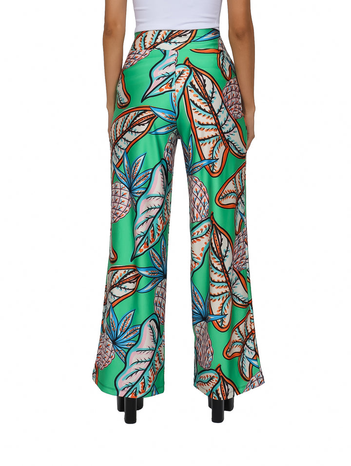 Pantalón verde de pierna ancha con estampado tropical de piñas y hojas en tonos naranja y azul.