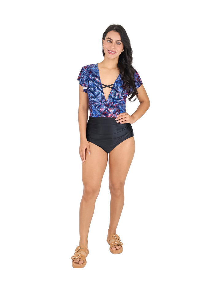Mujer vistiendo un traje de baño de una pieza con parte superior azul estampada y parte inferior negra.