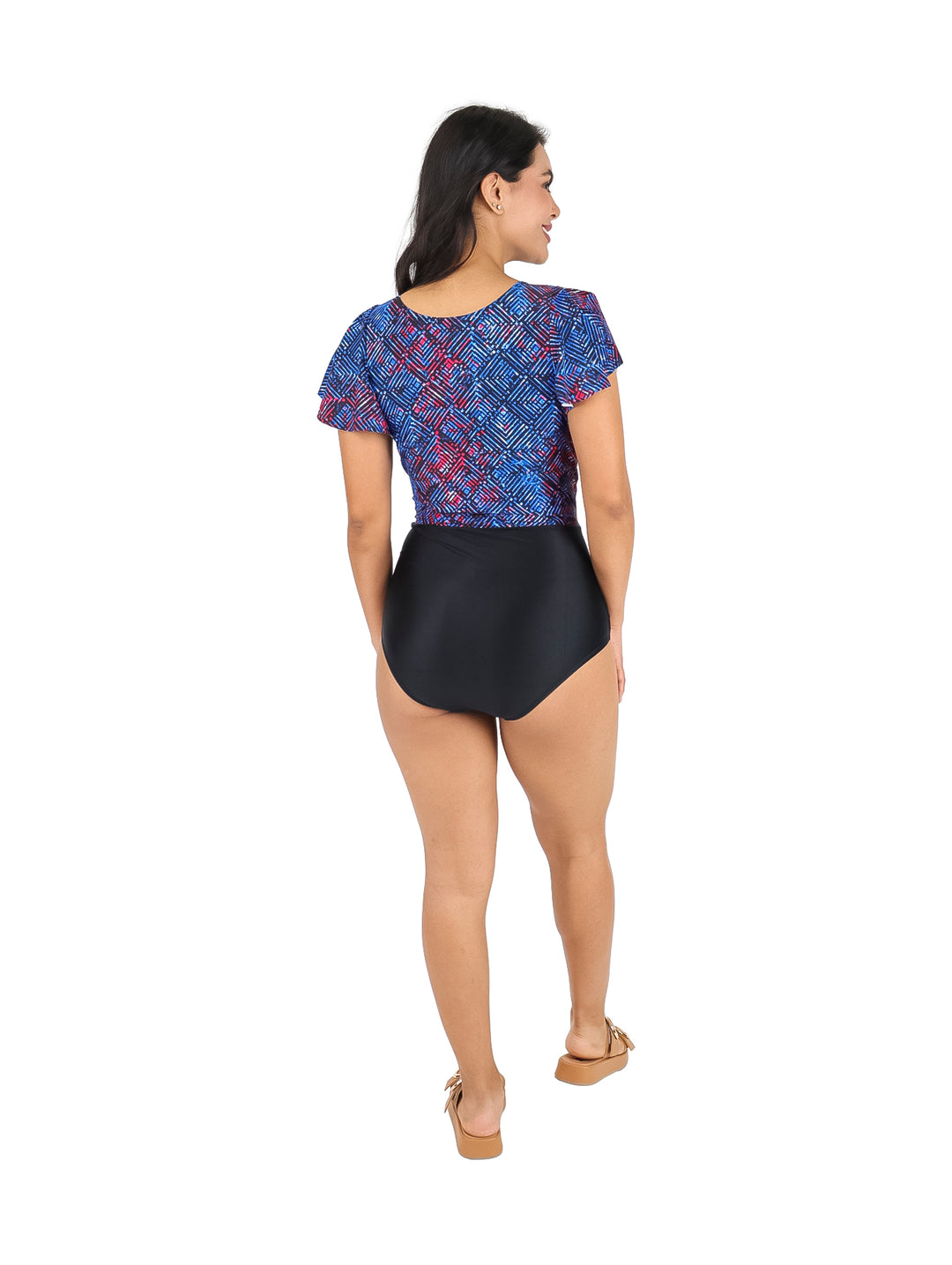 Mujer vistiendo un traje de baño de una pieza con parte superior azul estampada y parte inferior negra.