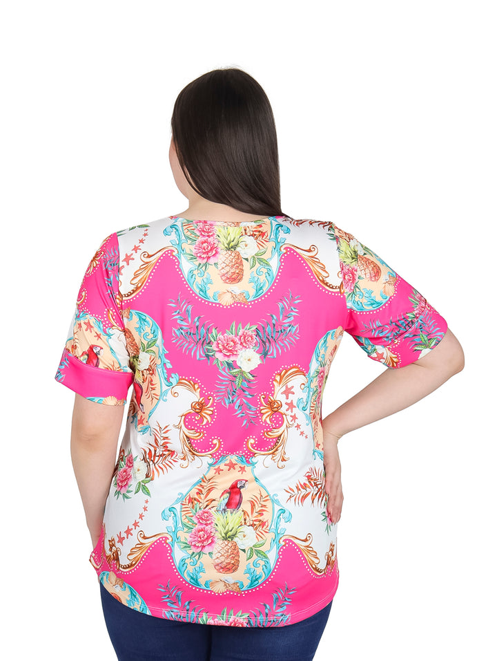 Mujer vistiendo blusa de manga corta color fushia y blanco con estampado floral colorido.