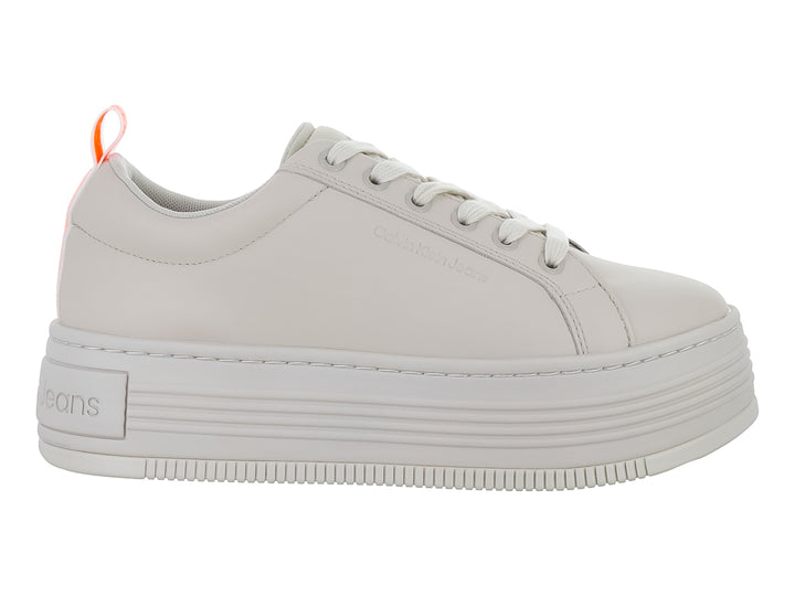 Tenis Calvin Klein de color beige con suela de plataforma gruesa y cordones blancos.