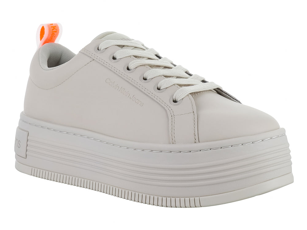Tenis Calvin Klein de color beige con suela de plataforma gruesa y cordones blancos.