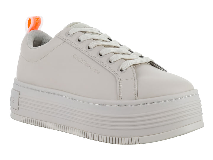 Tenis Calvin Klein de color beige con suela de plataforma gruesa y cordones blancos.