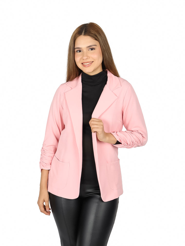 Mujer vistiendo un saco color rosa claro con mangas 3/4 surcidas y cuello solapa.
