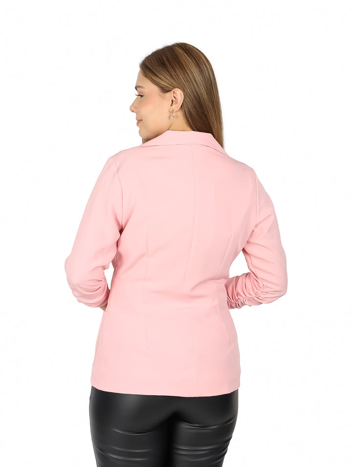 Mujer vistiendo un saco color rosa claro con mangas 3/4 surcidas y cuello solapa.