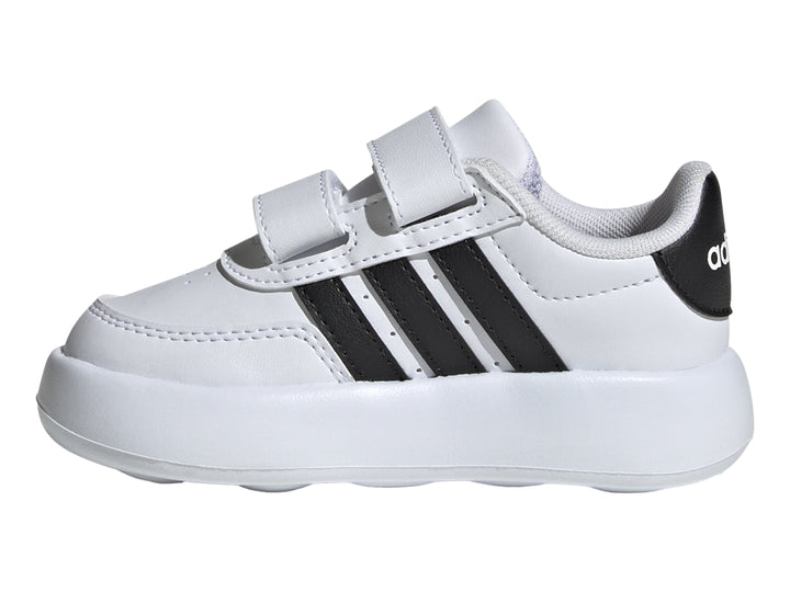 Tenis Adidas blancos para niño con tres franjas negras y cierre de velcro.