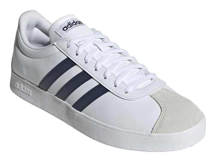 Tenis Adidas blancos con tres franjas azul marino y punta de gamuza gris.