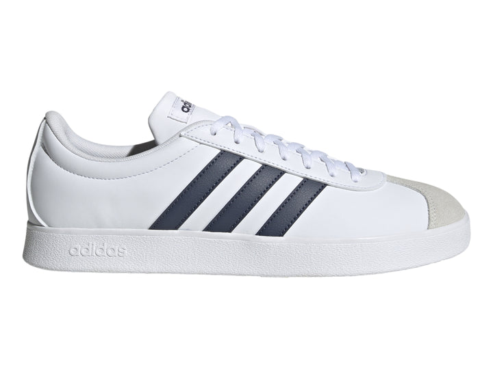 Tenis Adidas blancos con tres franjas azul marino y punta de gamuza gris.