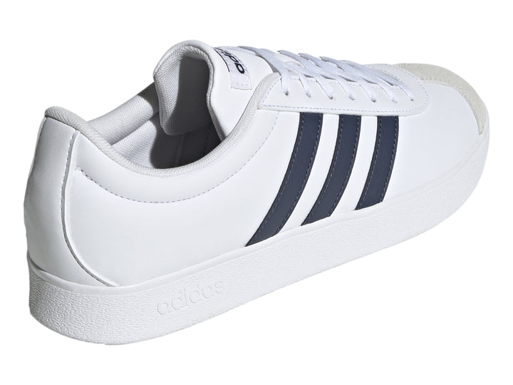 Tenis Adidas blancos con tres franjas azul marino y punta de gamuza gris.