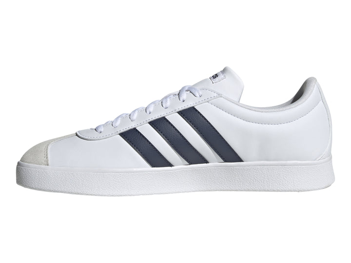 Tenis Adidas blancos con tres franjas azul marino y punta de gamuza gris.
