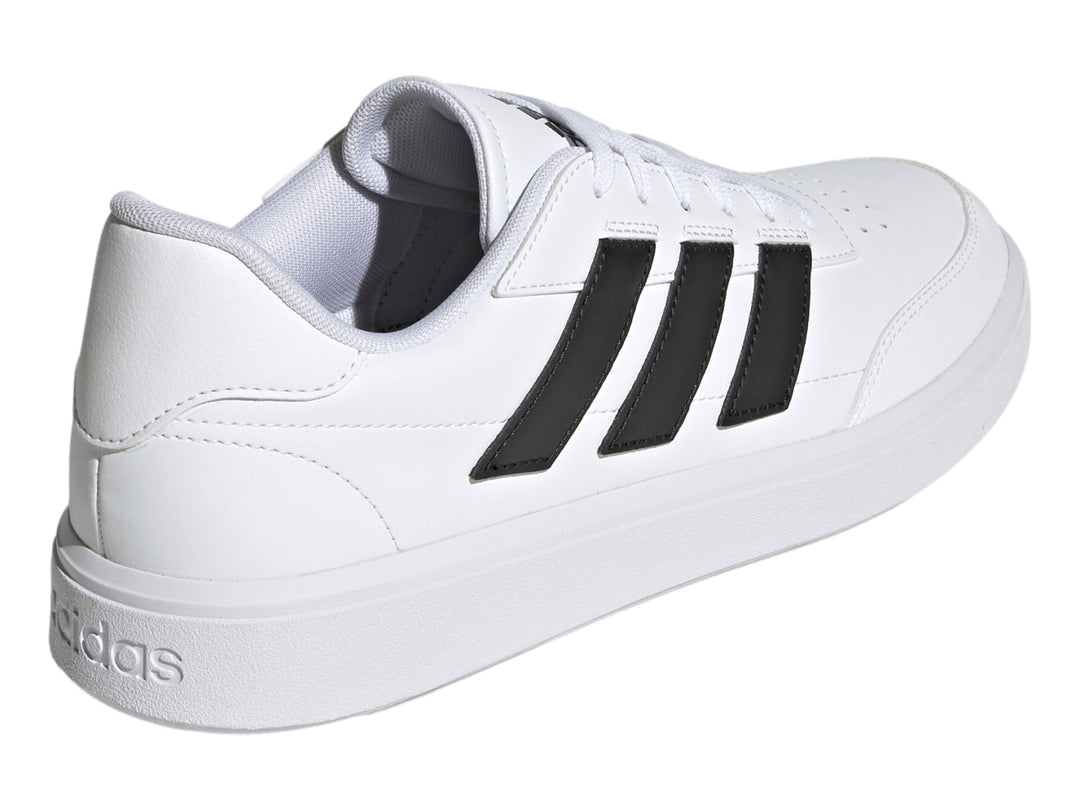Tenis Adidas Courtblock blancos con tres franjas negras laterales y suela blanca.