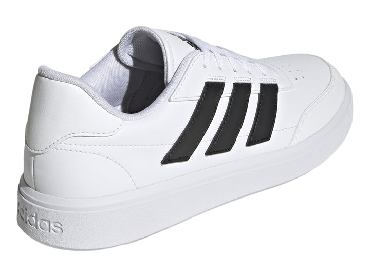 Tenis Adidas Courtblock blancos con tres franjas negras laterales y suela blanca.
