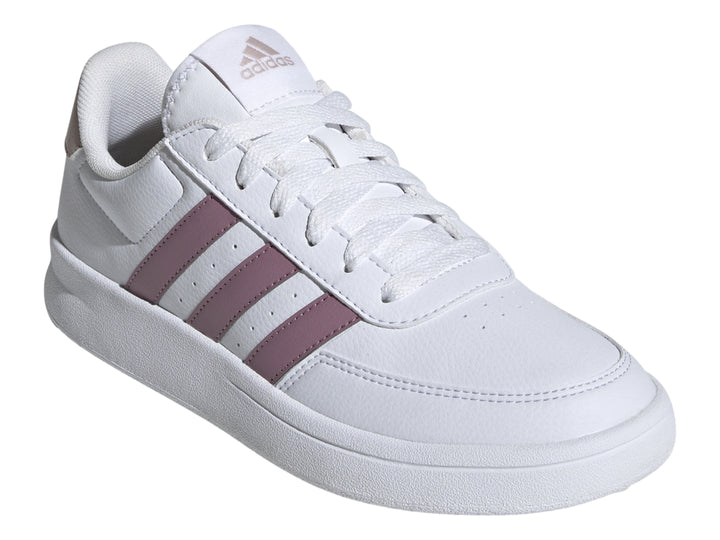 Tenis Adidas blancos con tres franjas moradas y detalle beige en el talón.