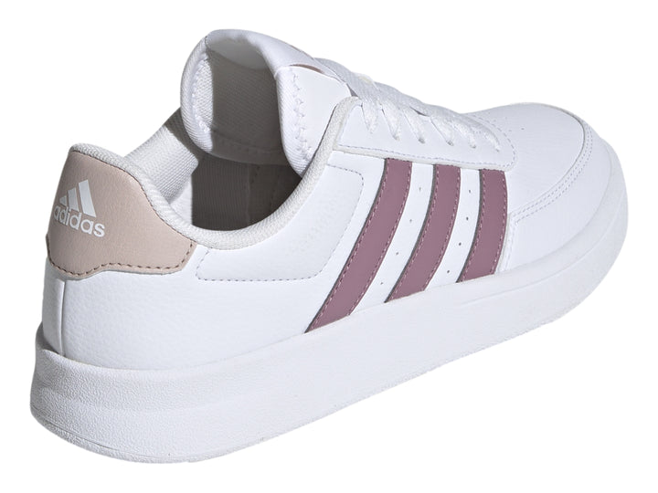 Tenis Adidas blancos con tres franjas moradas y detalle beige en el talón.