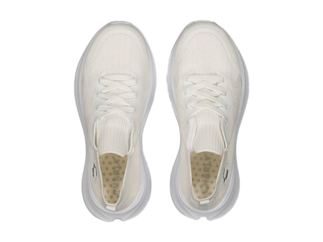 Tenis deportivos Charly color blanco con parte superior tejida y suela blanca.