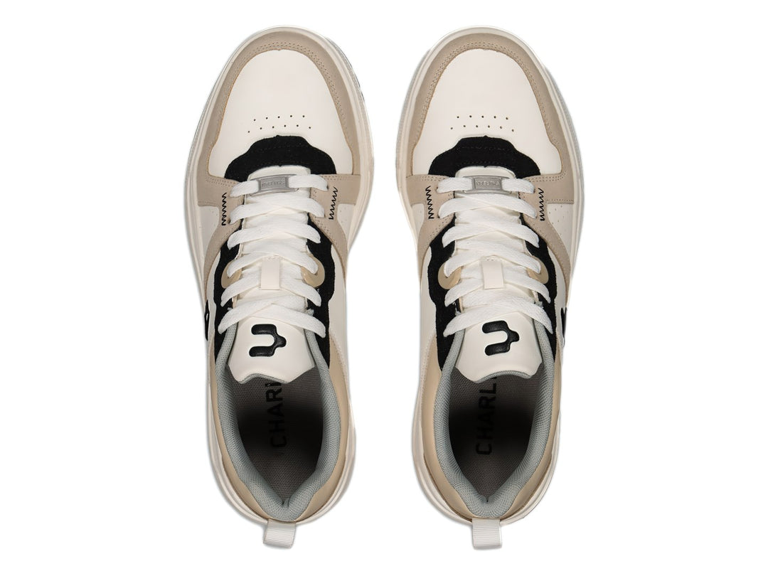 Tenis deportivos Charly en colores blanco, beige y negro con suela blanca y cordones.