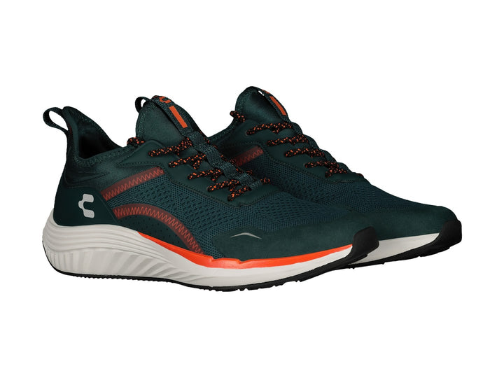 Tenis deportivos Charly color verde oscuro con detalles en naranja y suela blanca.