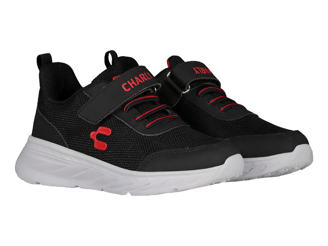 Tenis deportivos Charly para niño en color negro con suela blanca y detalles en rojo, cierre de velcro y agujetas.