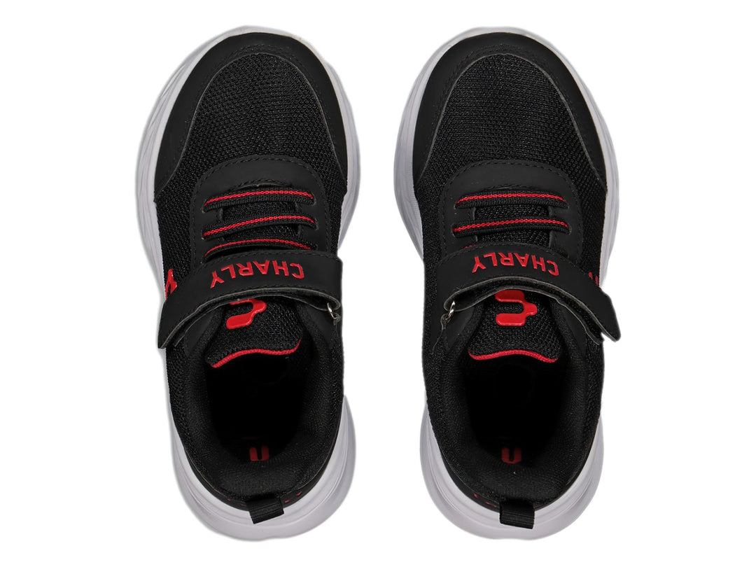 Tenis deportivos Charly para niño en color negro con suela blanca y detalles en rojo, cierre de velcro y agujetas.