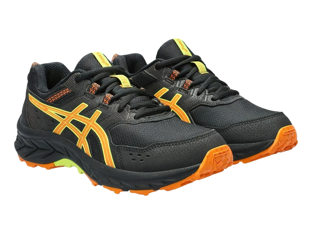 Tenis deportivos ASICS color negro con detalles en naranja y verde lima para niños.