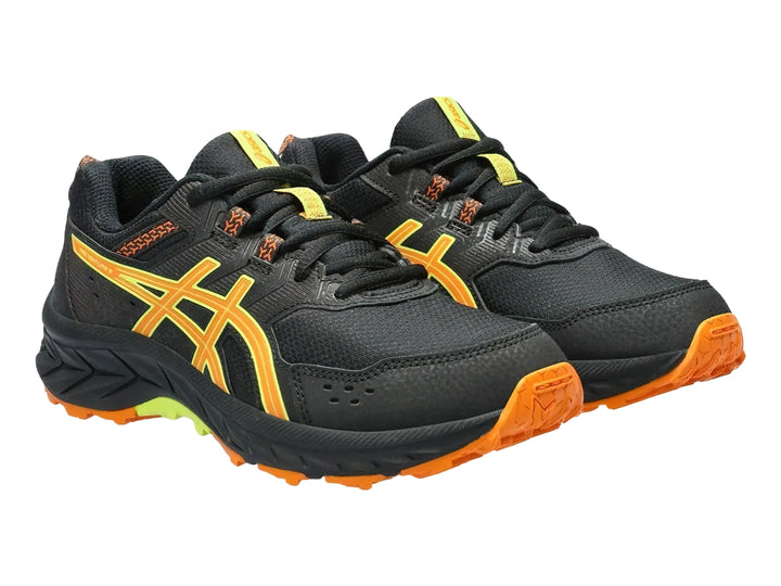 Tenis deportivos ASICS color negro con detalles en naranja y verde lima para niños.