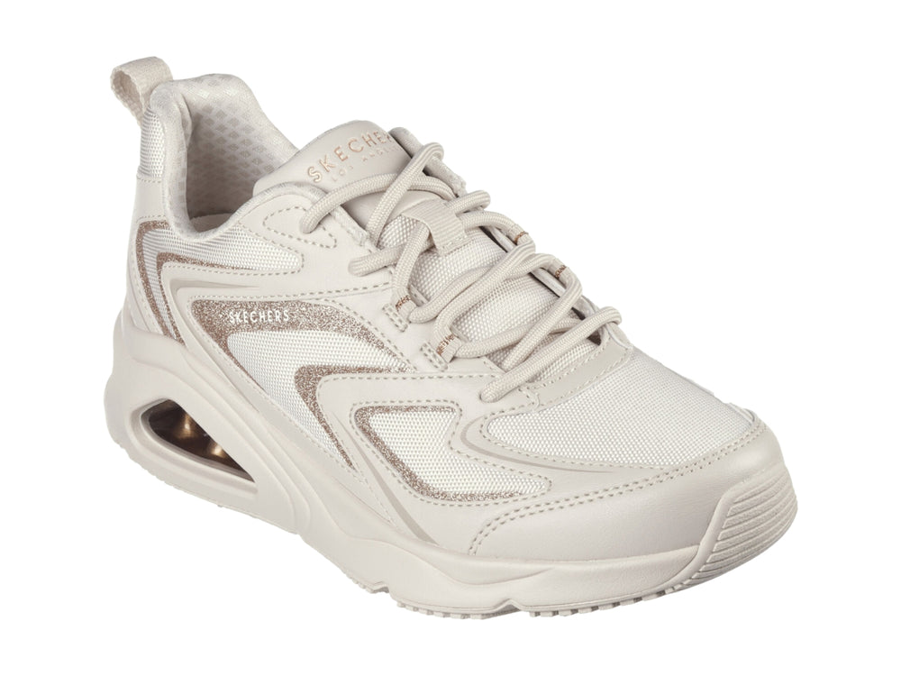 Tenis deportivos Skechers color blanco con detalles dorados y suela con cámara de aire visible.