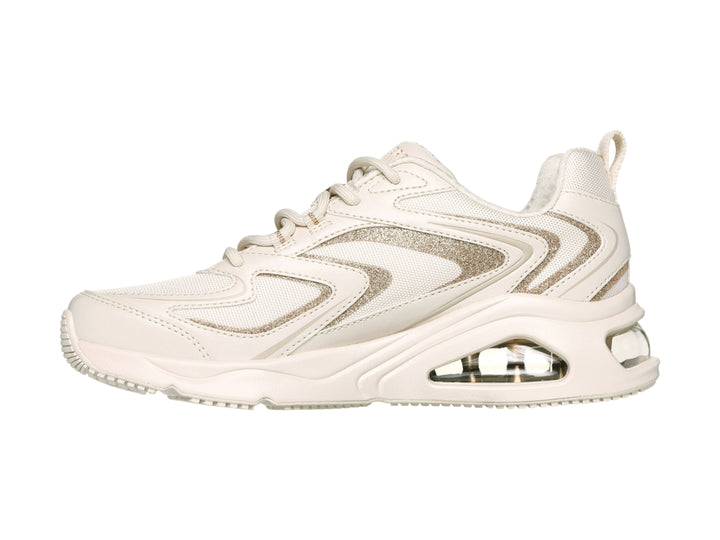 Tenis deportivos Skechers color blanco con detalles dorados y suela con cámara de aire visible.
