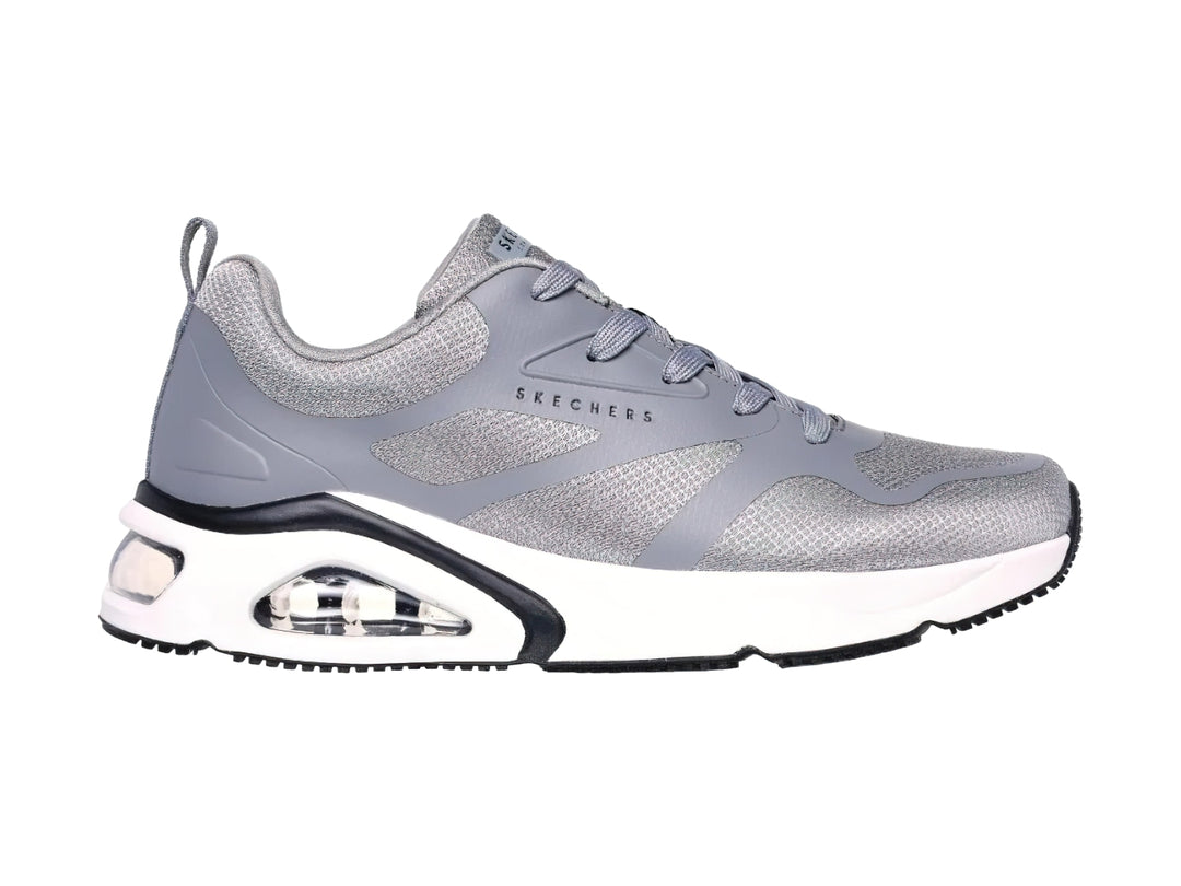 Tenis deportivos Skechers en color gris con suela blanca y detalles en negro.