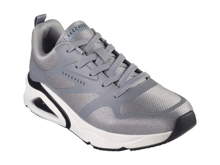 Tenis deportivos Skechers en color gris con suela blanca y detalles en negro.