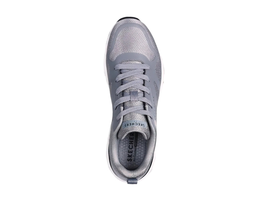 Tenis deportivos Skechers en color gris con suela blanca y detalles en negro.