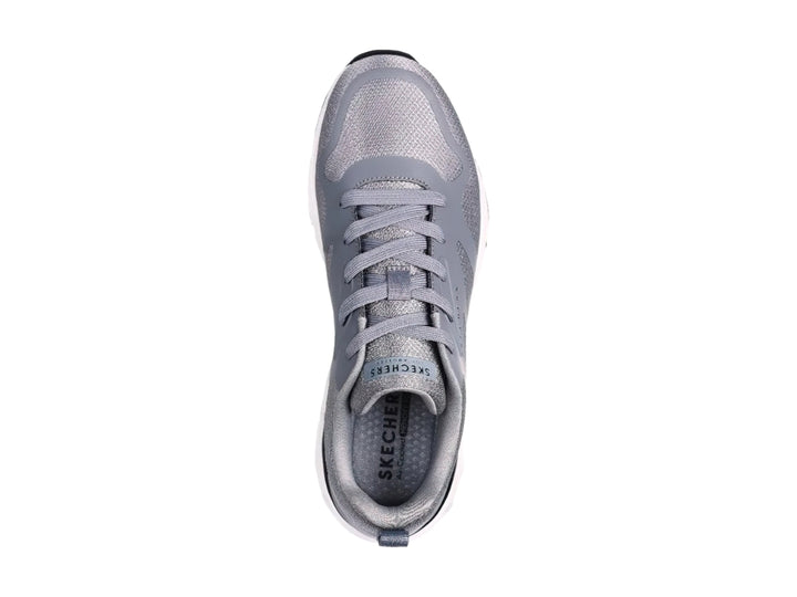 Tenis deportivos Skechers en color gris con suela blanca y detalles en negro.