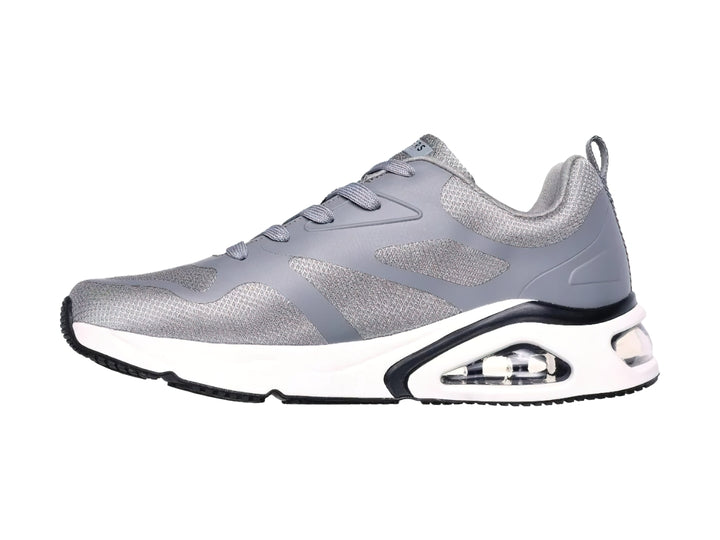 Tenis deportivos Skechers en color gris con suela blanca y detalles en negro.