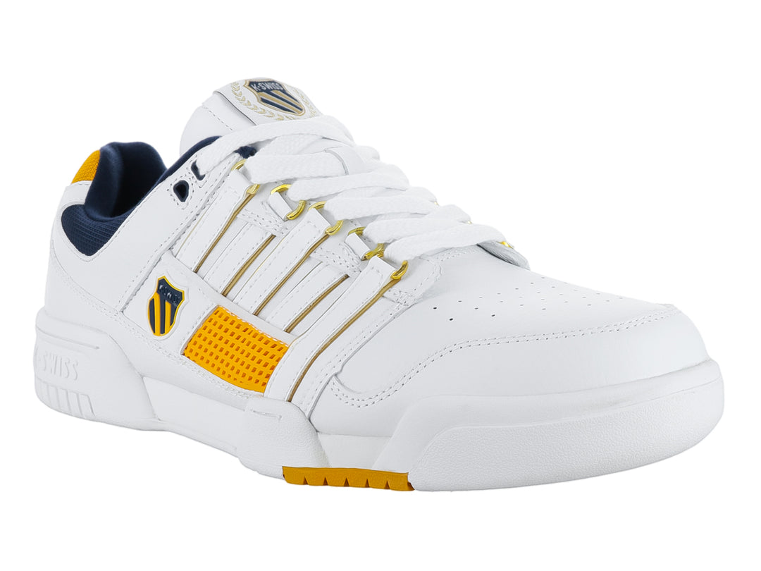 Tenis K-Swiss G-Staad en color blanco con detalles en dorado y azul marino.