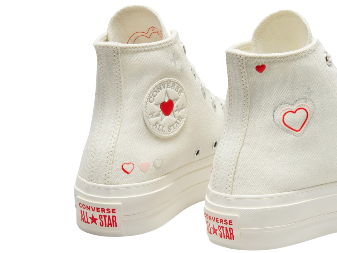 Tenis Converse Chuck Taylor All Star Lift Hi en color blanco hueso con detalles de corazones rojos y suela elevada.