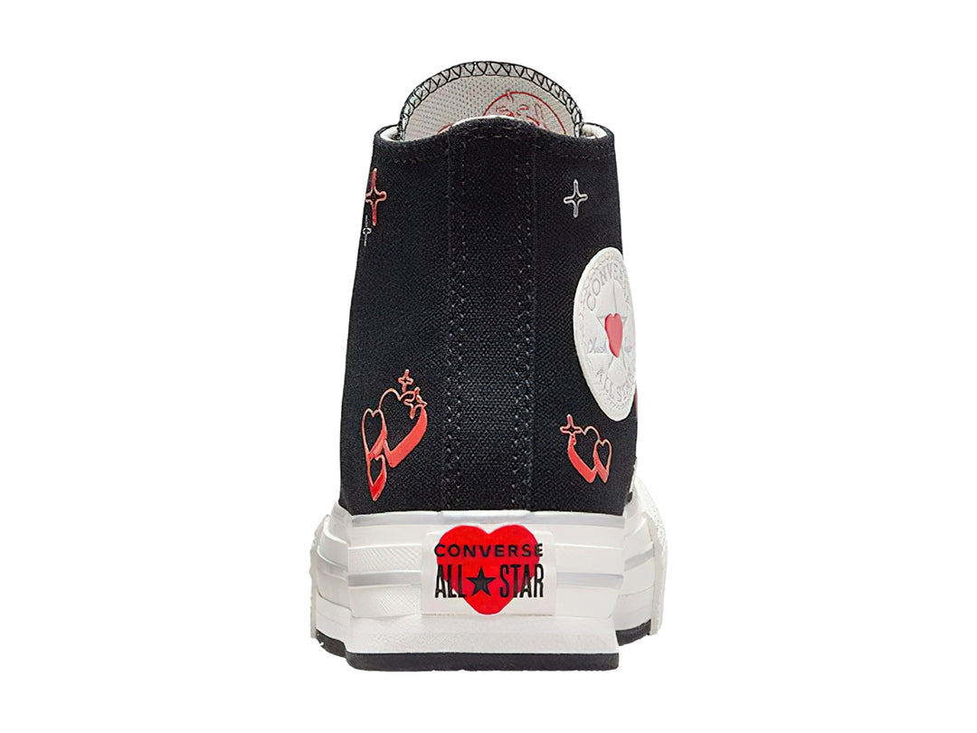 Tenis Converse botín color negro con suela blanca de plataforma y detalles de corazones rojos.