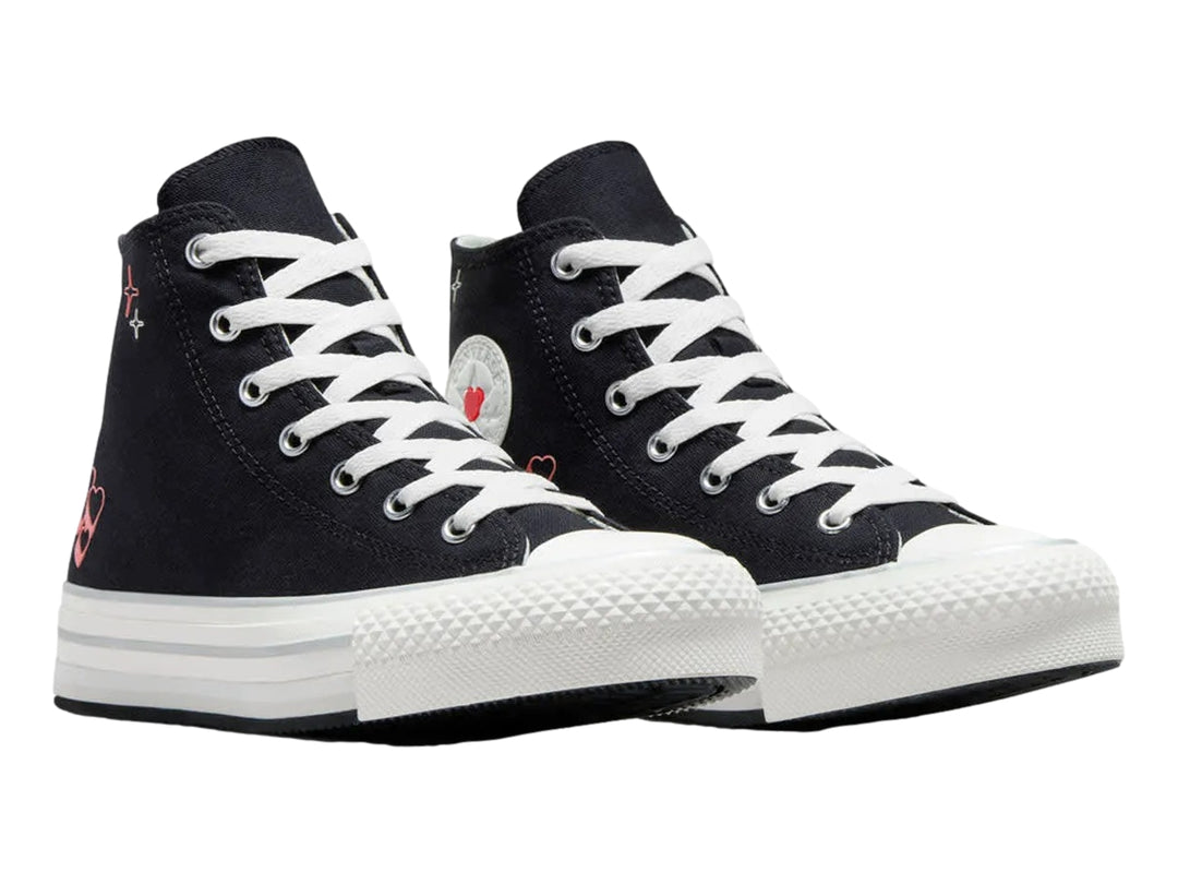 Tenis Converse negros de bota con suela blanca de plataforma y pequeños corazones rojos decorativos.