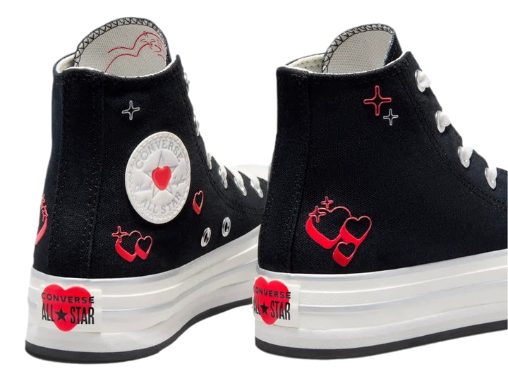 Tenis Converse negros de bota con suela blanca de plataforma y pequeños corazones rojos decorativos.