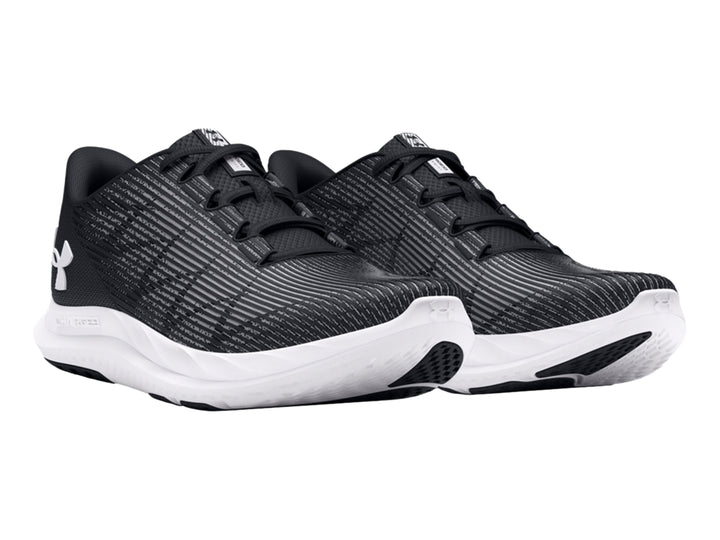 Tenis deportivos Under Armour en color negro con suela blanca, vista de perfil.