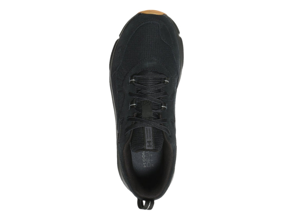 Tenis deportivo Under Armour de color negro con suela marrón, vista lateral.